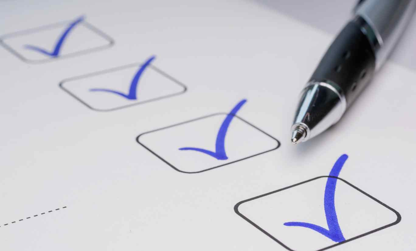 Picture of pen and checklist, how to optimise Google Ads: 7 Tips