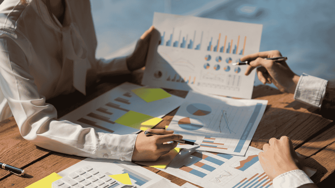 office workers meeting around stats, graphs and paper