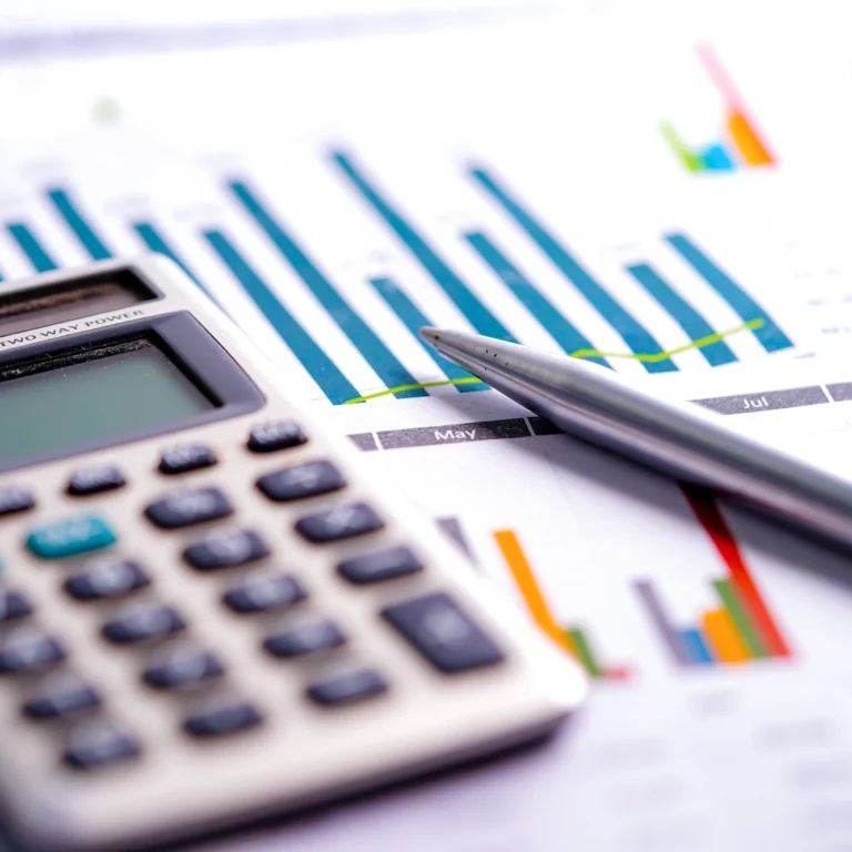 Calculator and pen resting on top of financial documents, symbolising budgeting and financial planning.