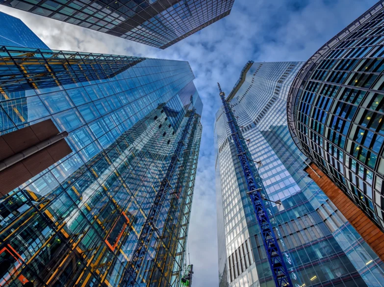 A view looking up at the top of a tall building against a clear blue sky.