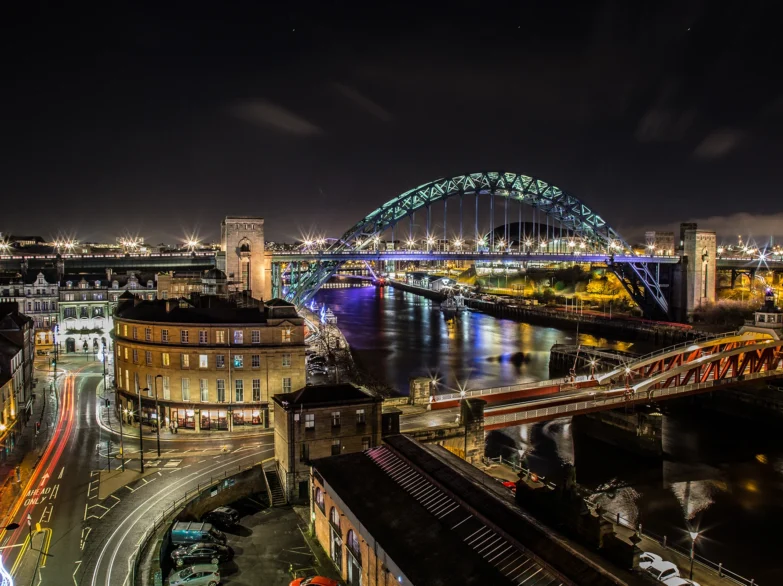 Newcastle Quayside cityscape illuminated at night.