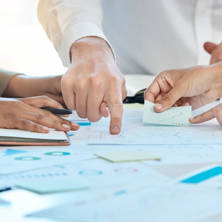 A diverse group of people collaborating on a project around a table, sharing ideas and working together.