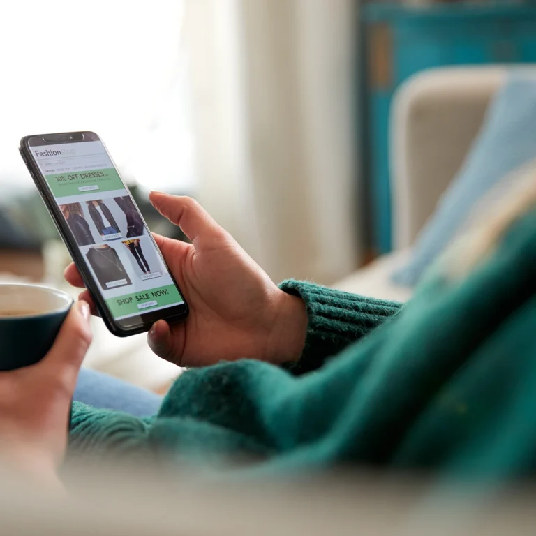 A woman shopping for clothes on her phone using a shopping app.