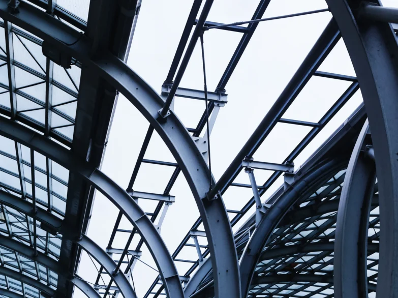 A large, modern building featuring extensive glass windows reflecting the surrounding environment.