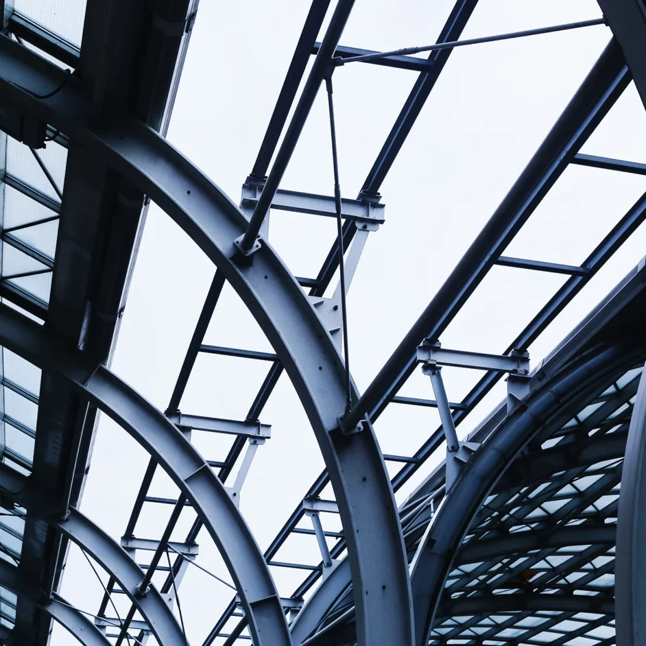A large, modern building featuring extensive glass windows reflecting the surrounding environment.