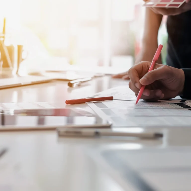 Businessman focused on developing a business plan, surrounded by notes and a laptop in a modern office setting.
